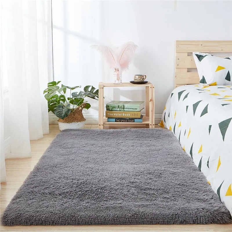 Thảm trải sàn màu xám đặt cạnh giường trong phòng ngủ