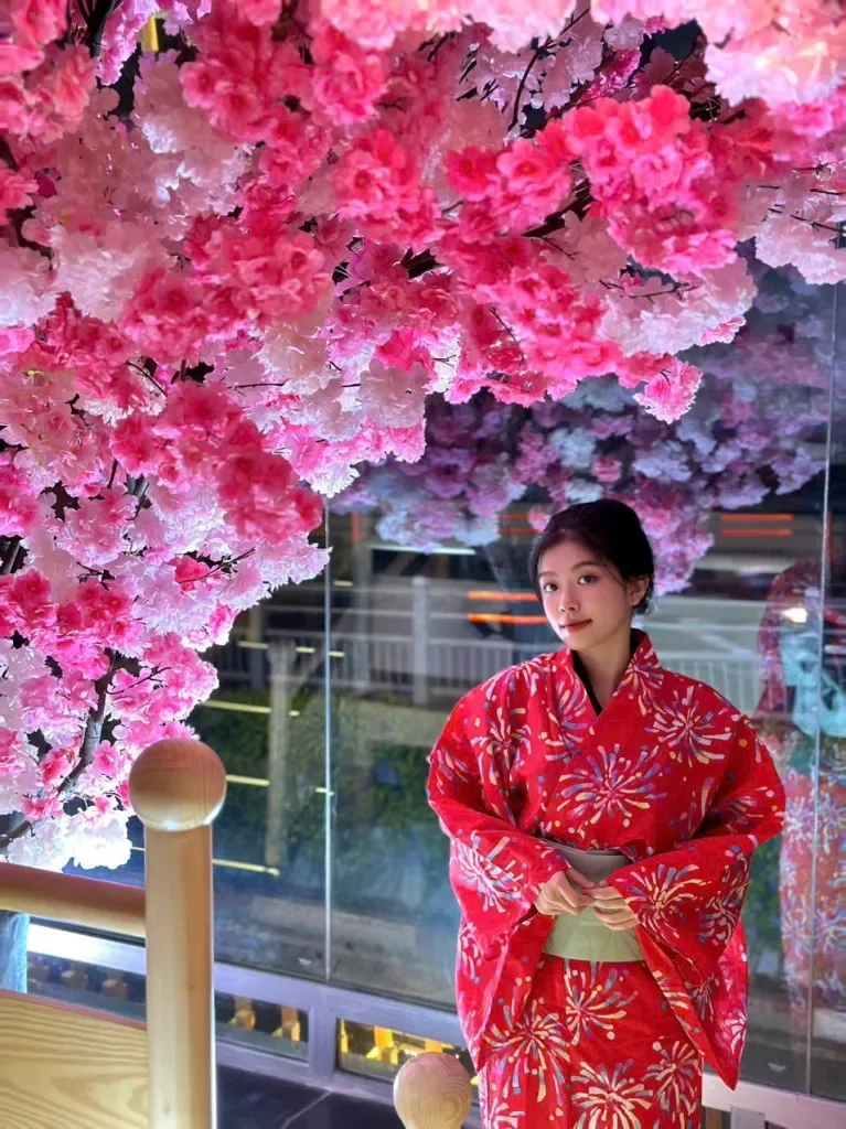 Cô gái Nhật Bản mặc kimono đỏ dưới tán hoa anh đào rực rỡ