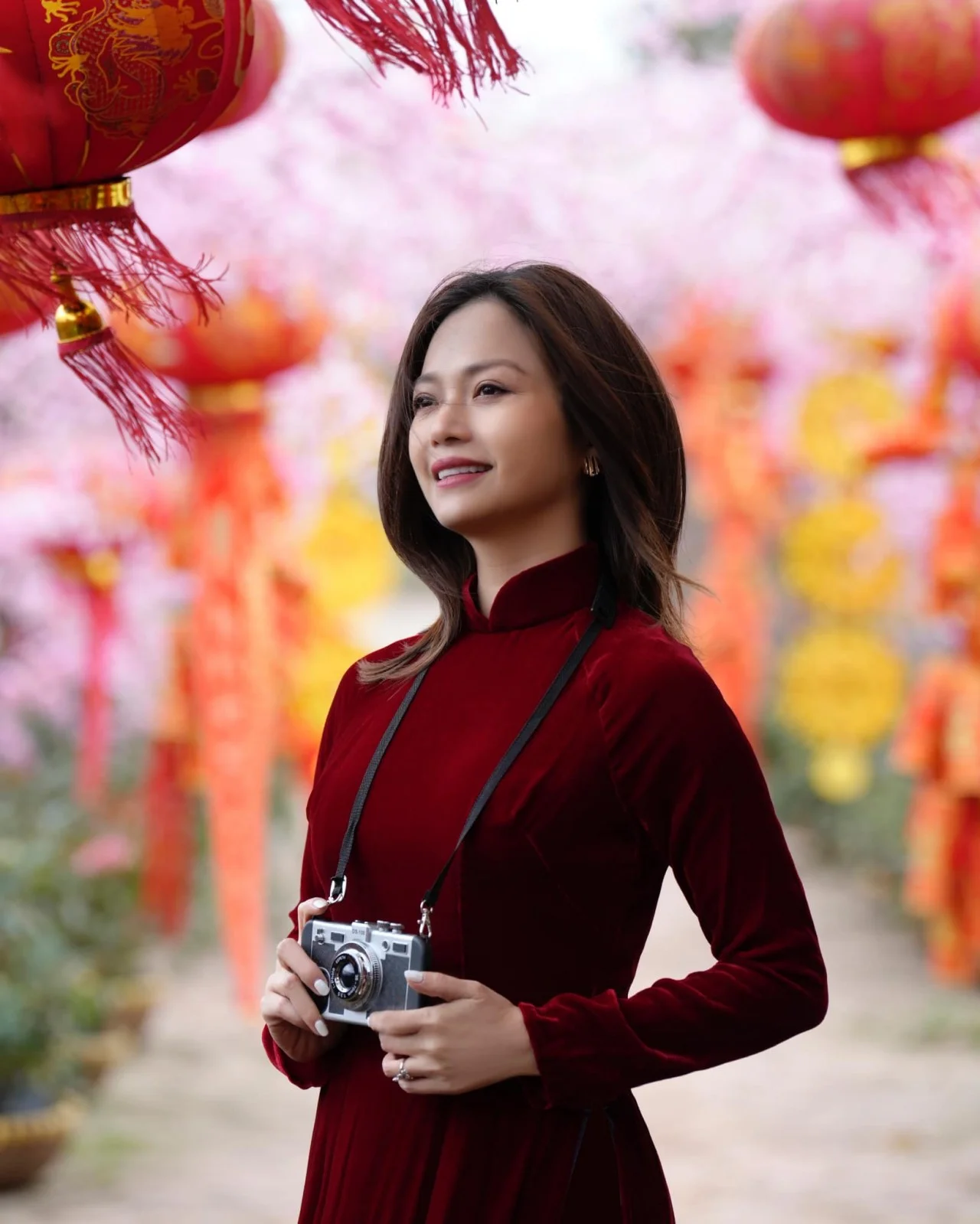 Diễn viên Kiều Anh mặc áo dài đỏ chụp ảnh xuân